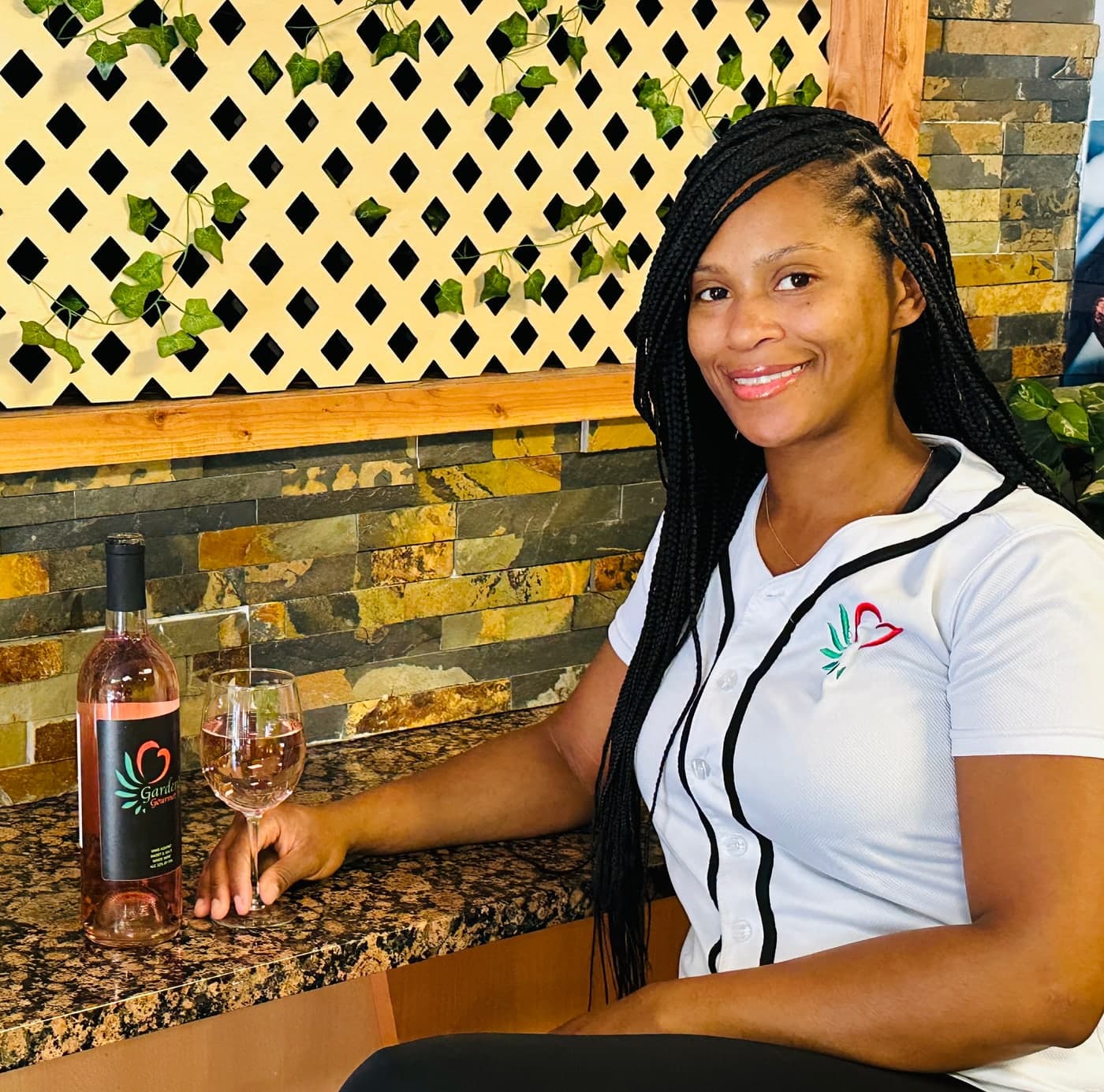 Nyesha, founder of Garden's Gourmet, at the counter with a bottle of Garden's wine